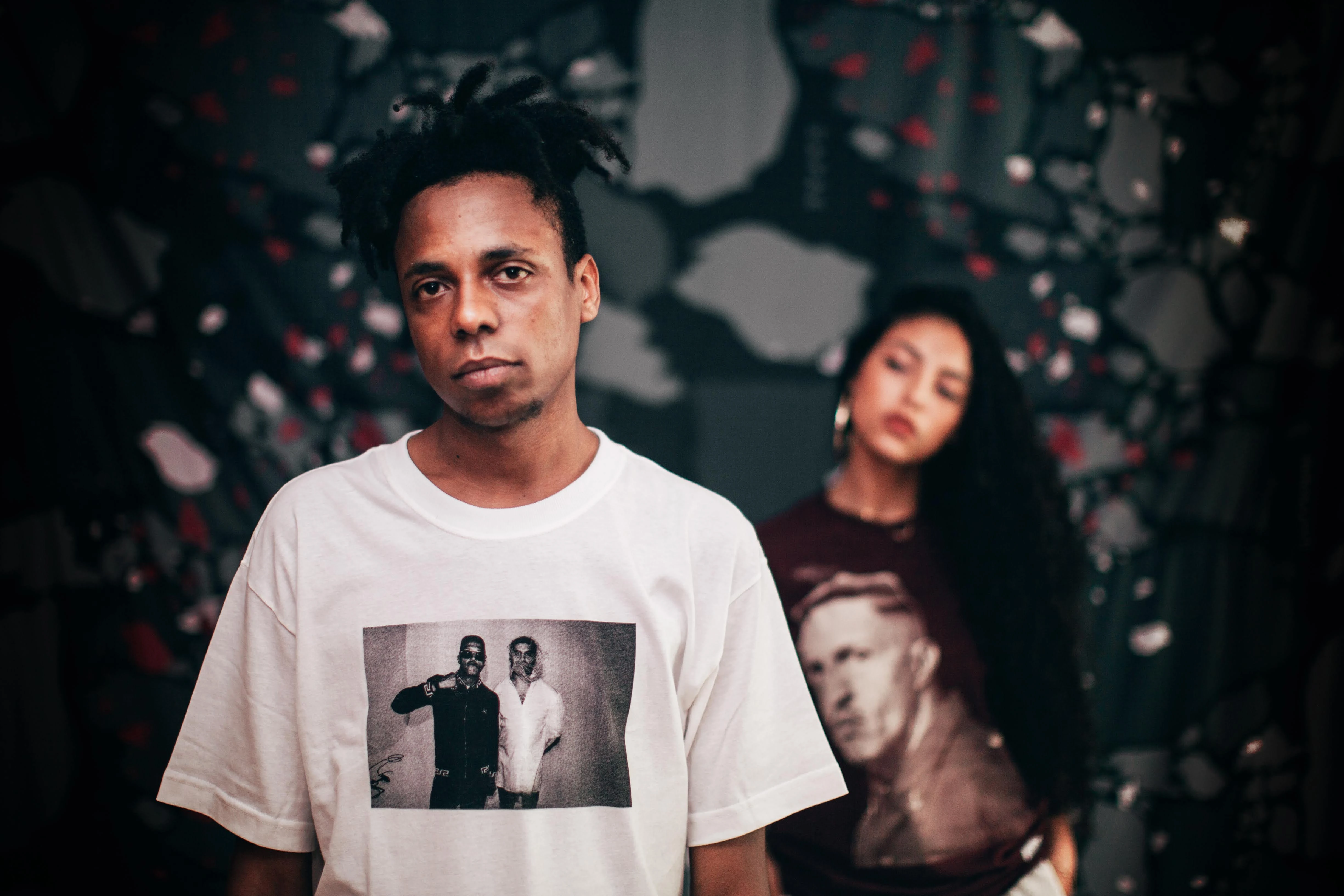 Two models in collection T-shirts printed with a photograph of Criolo and Mano Brown.