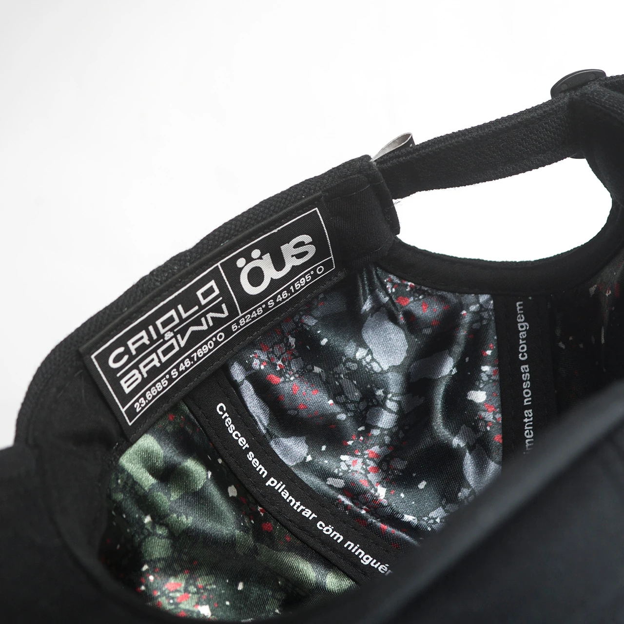 The inside of a cap showing the printed lining and the Criolo Brown x ÖUS woven label.